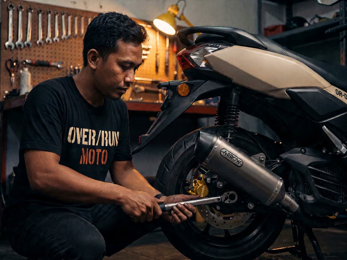 Mechanic's hands torquing a bolt on a scooter engine